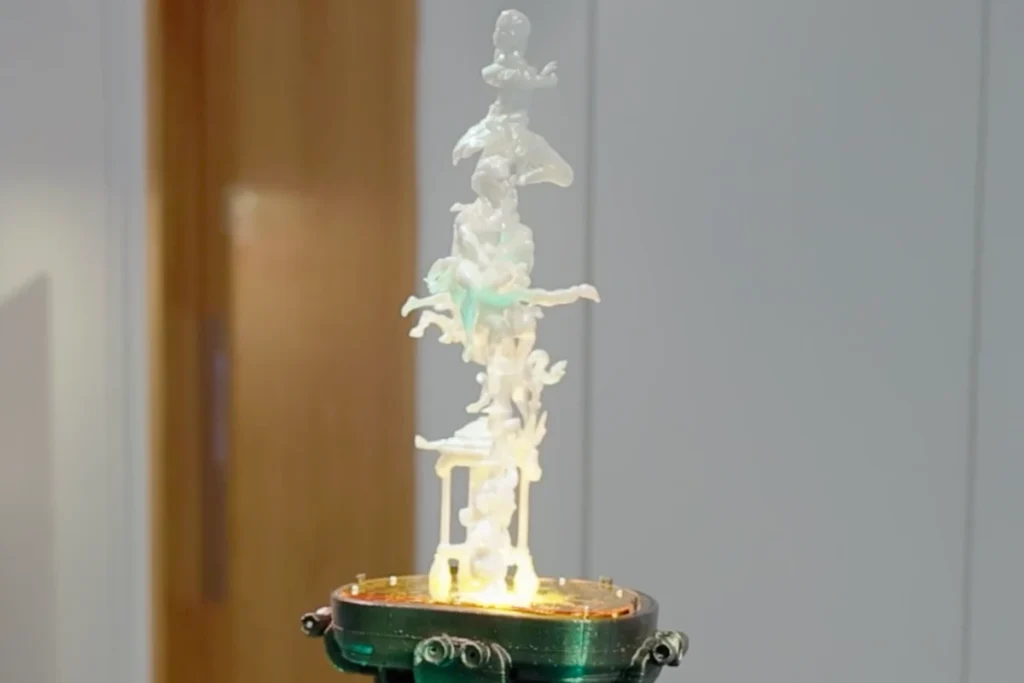 Sculpture made of several abstract figures stacked on top of each other on a round base against a blurred background